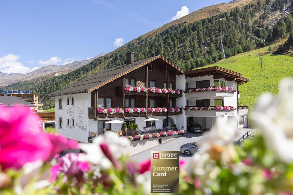 a building with flowers in front of a mountain at Haus Verwall in Obergurgl