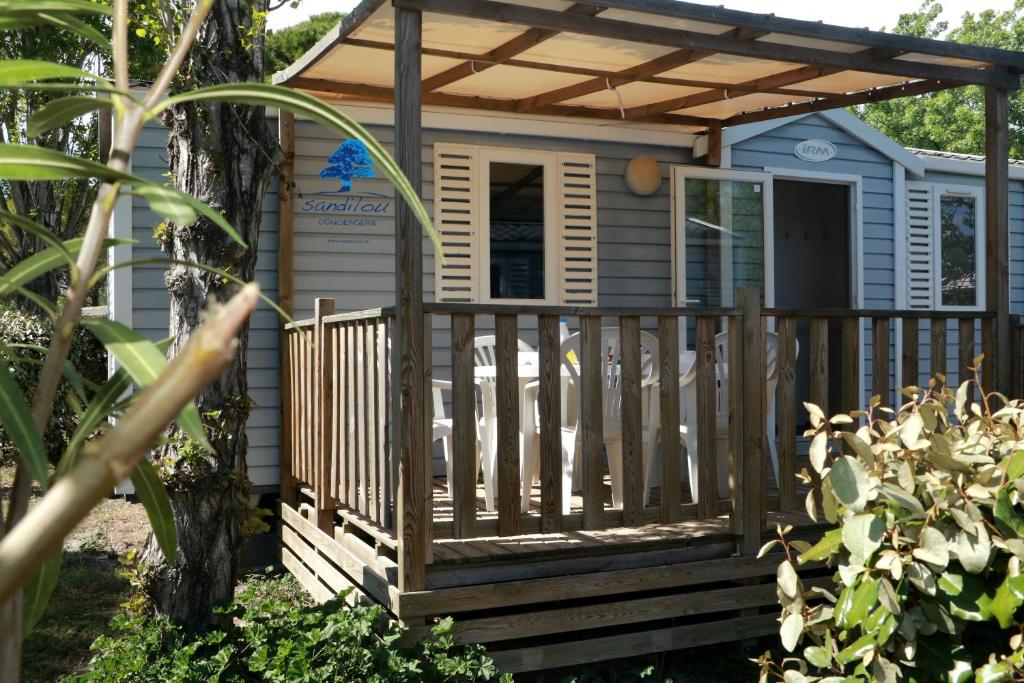 a tiny house with a porch and a pergola at Mobilhome «La mouette rieuse» * 6 personnes *Climatisatisé *2 Chambres in Sigean