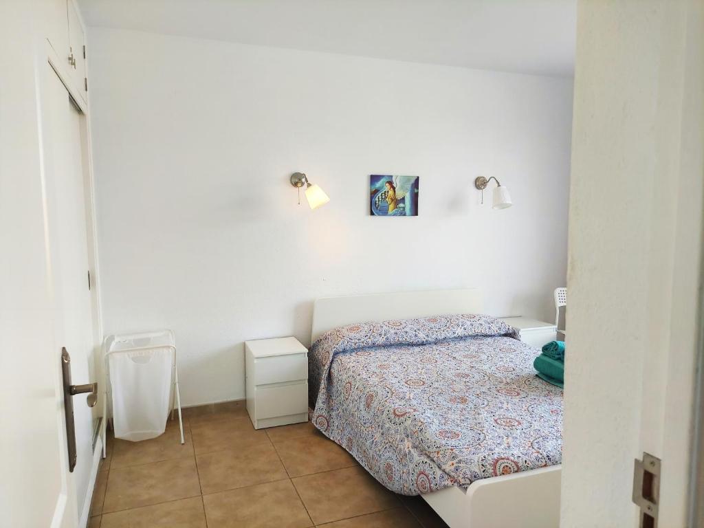 um quarto com uma cama e duas luzes na parede em BLU APARTMENT, WIFI FREE POOL VIEW em Costa Del Silencio