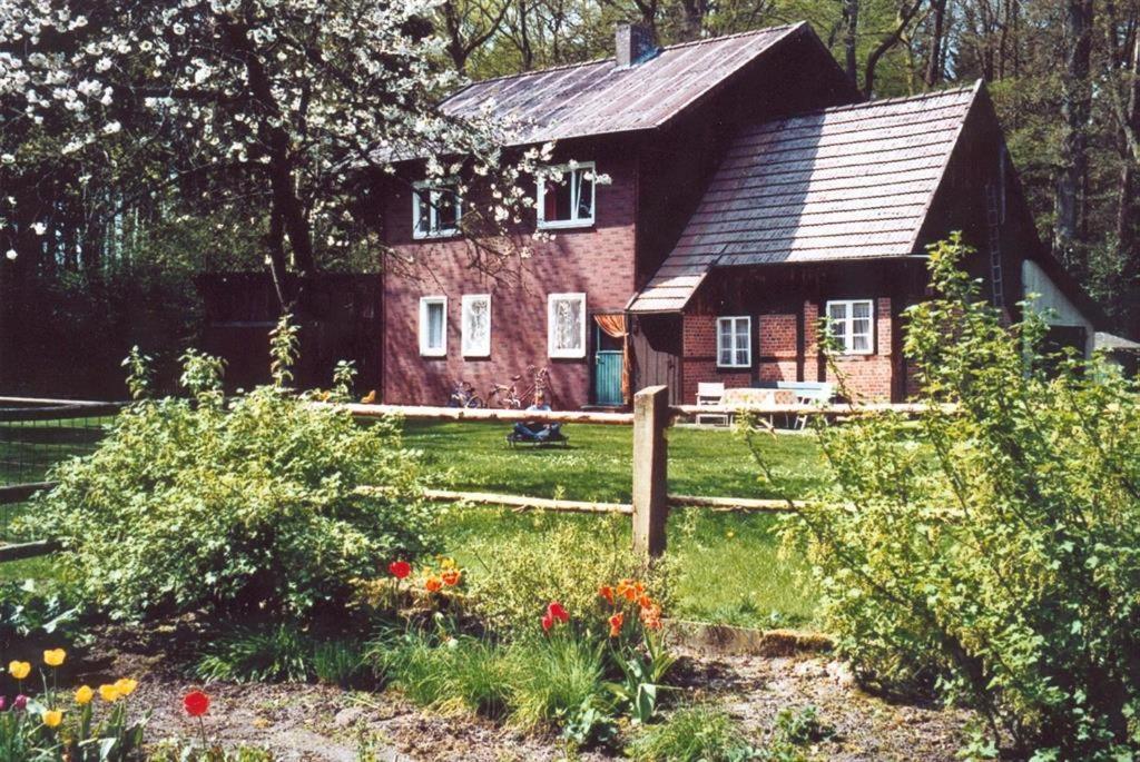 uma casa de tijolos vermelhos no meio de um quintal em Hof Schlüpke em Hermannsburg