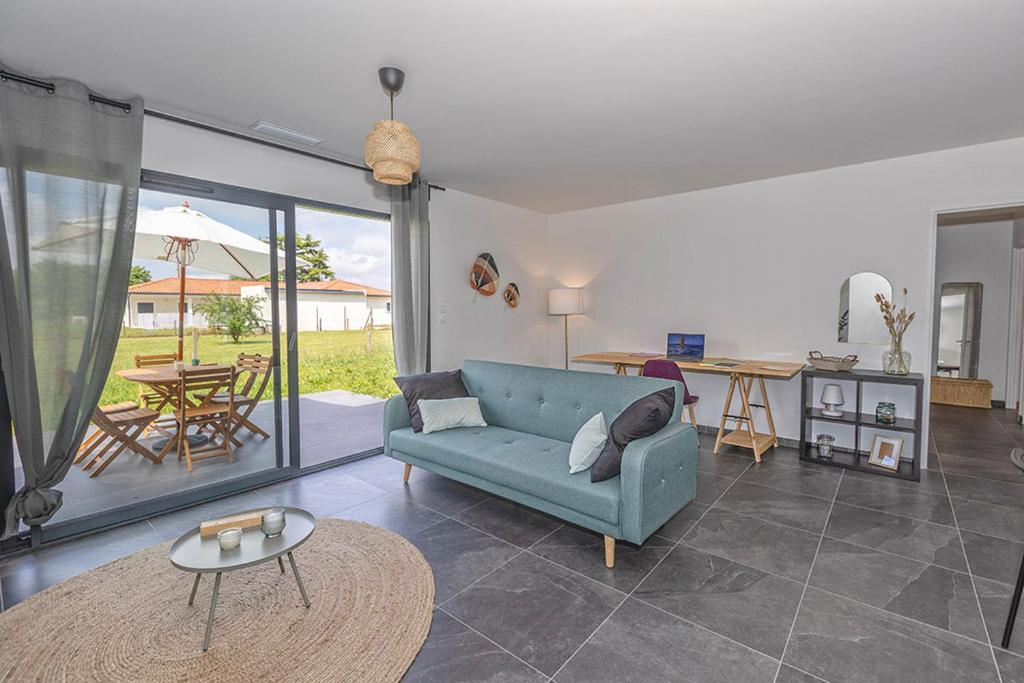 uma sala de estar com um sofá azul e uma mesa em La Marssacoise em Marssac-sur-Tarn
