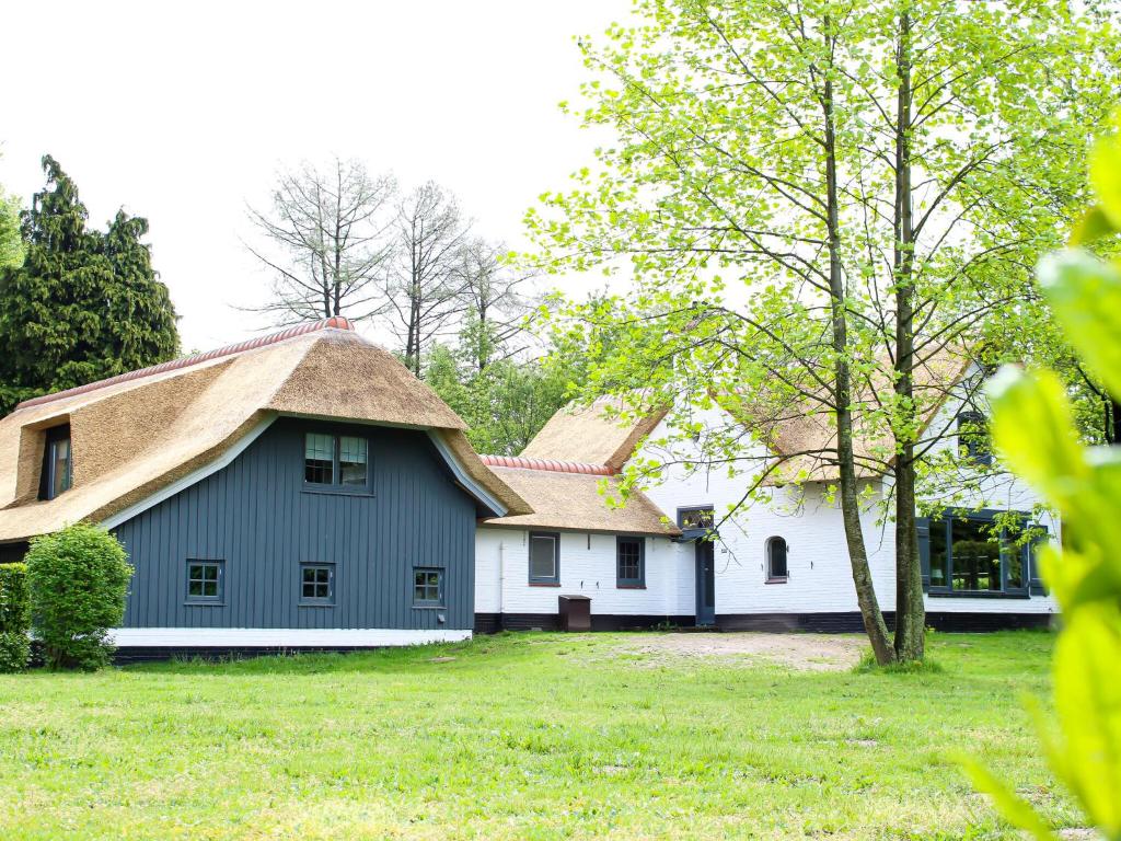 フルスホルストにあるCharming Holiday Home in Hulshorst with Swimming Poolの茅葺き屋根の大白い家