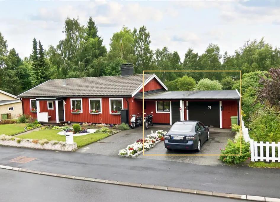 a red house with a car parked in front of it at Nice Entire Semi - Attached House - M in Umeå