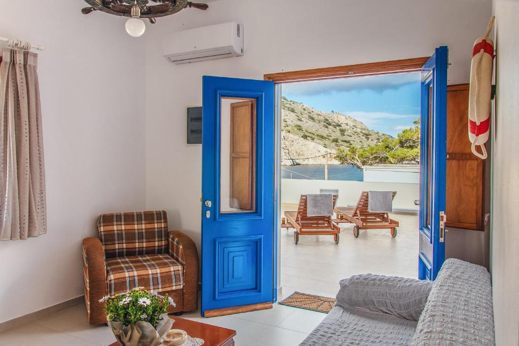 a blue door leading to a living room with chairs at Symi Filoxenia in Symi