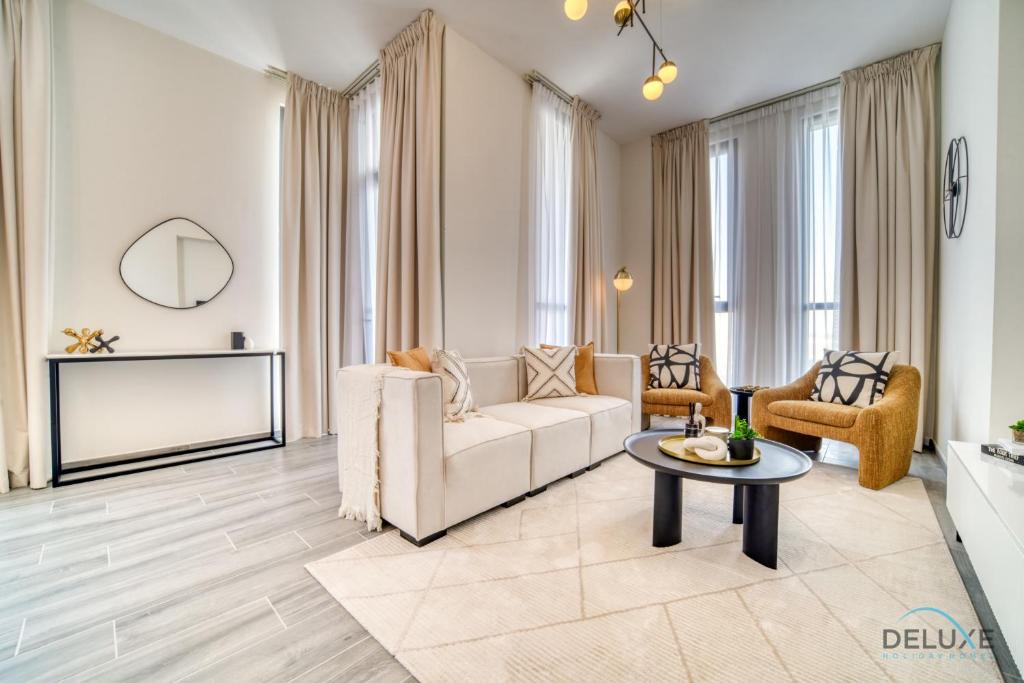 ein Wohnzimmer mit einem Sofa und einem Tisch in der Unterkunft Charming 2BR with Assistant Room at Mesk 1 Midtown Dubai Production City by Deluxe Holiday Homes in Dubai