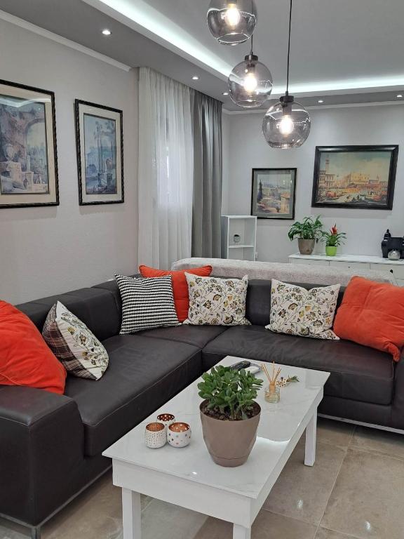 a living room with a black couch and a table at Elegance apartment in Paleo Tsifliki