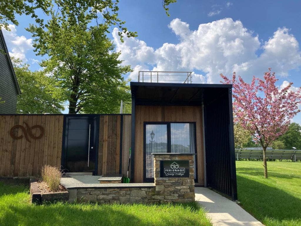 ein kleines Gebäude mit einem Schild im Hof in der Unterkunft Tiny House - Luxury Cottage in Büllingen