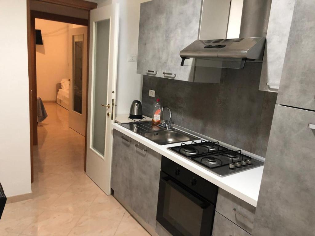 uma cozinha com um lavatório e um fogão forno superior em Manarola apartament em La Spezia