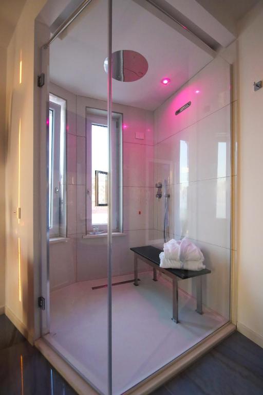 y baño con ducha acristalada y mesa. en Oldwell Hotel, en Santa Domenica