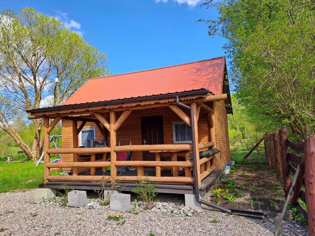 a log cabin with a red roof at Warmiński Domek 