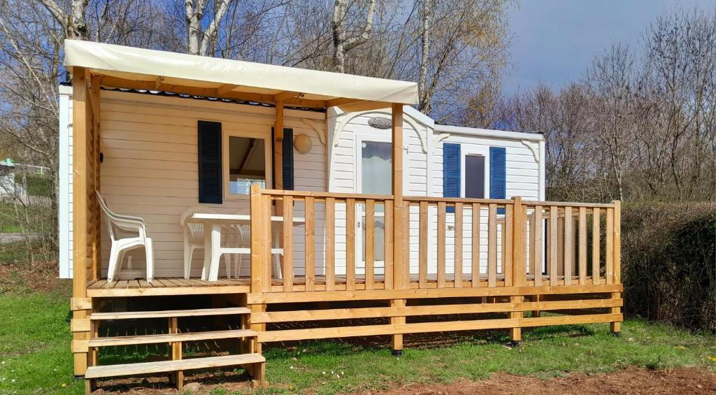 una casa pequeña con porche y cenador en Mobil home au bord du lac en Nages