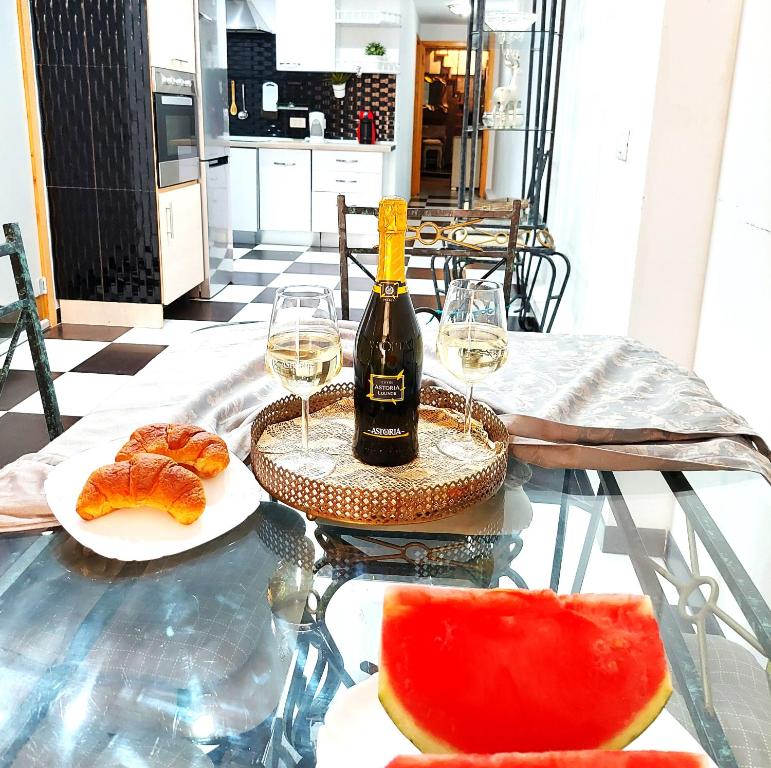 a glass table with a bottle of wine and a plate of food at ELEGANT 3 BEDROOMS, Wifi free in Adeje