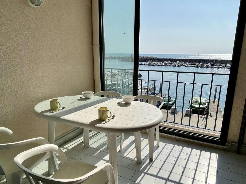 uma mesa e cadeiras numa varanda com vista para o oceano em Appartement Argelès-sur-Mer, 1 pièce, 4 personnes - FR-1-225-422 em Argelès-sur-Mer