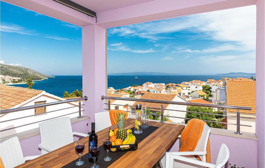 balcón con mesa y sillas y vistas al océano en Amazing Apartment In Okrug Gornji With Kitchen, en Trogir
