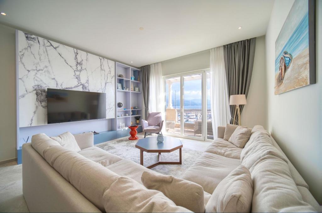 Lustica Bay Marina Village by 2BHome في لوستيكا: غرفة معيشة مع أريكة كبيرة وتلفزيون