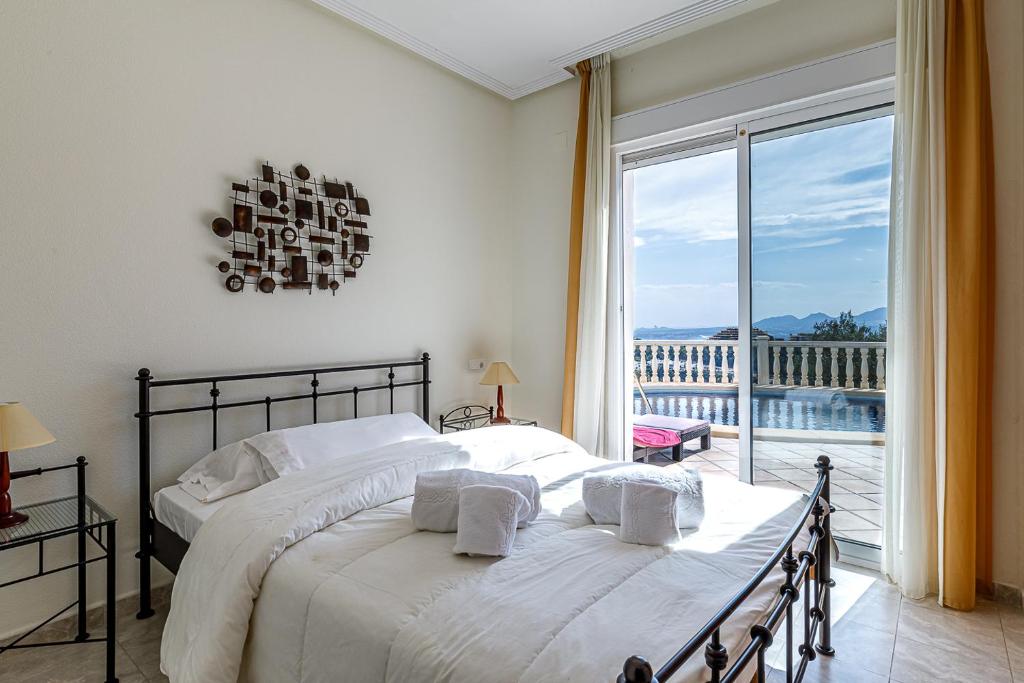 a bedroom with a large bed and a large window at Altea Buena Vista in Altea