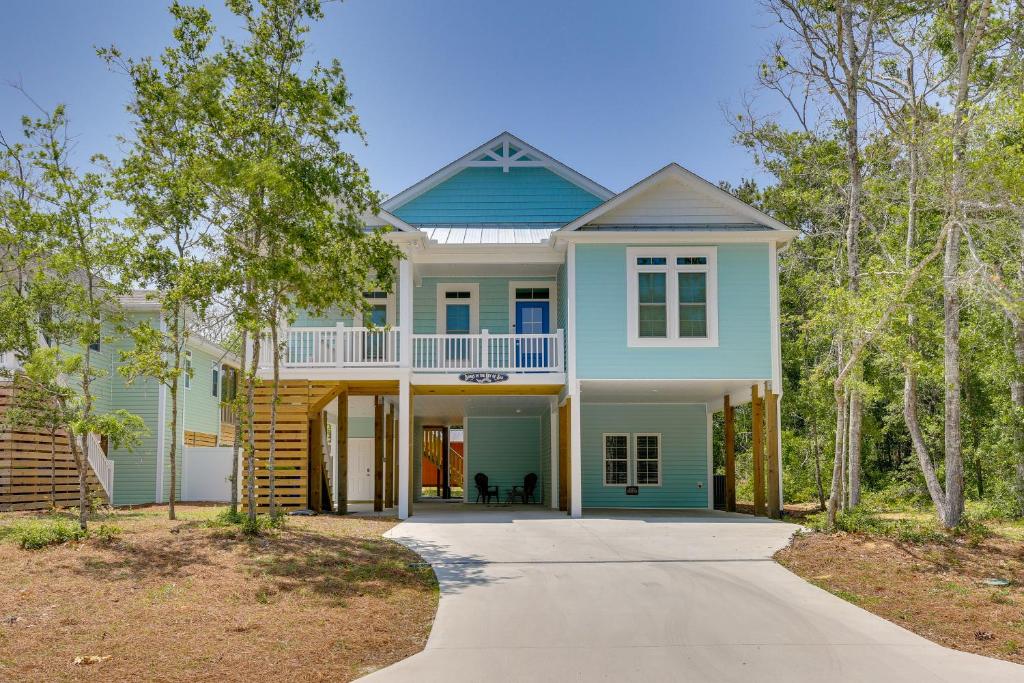 a home with a blue house with a driveway at Coastal North Carolina Retreat - Walk to Beach! in Oak Island