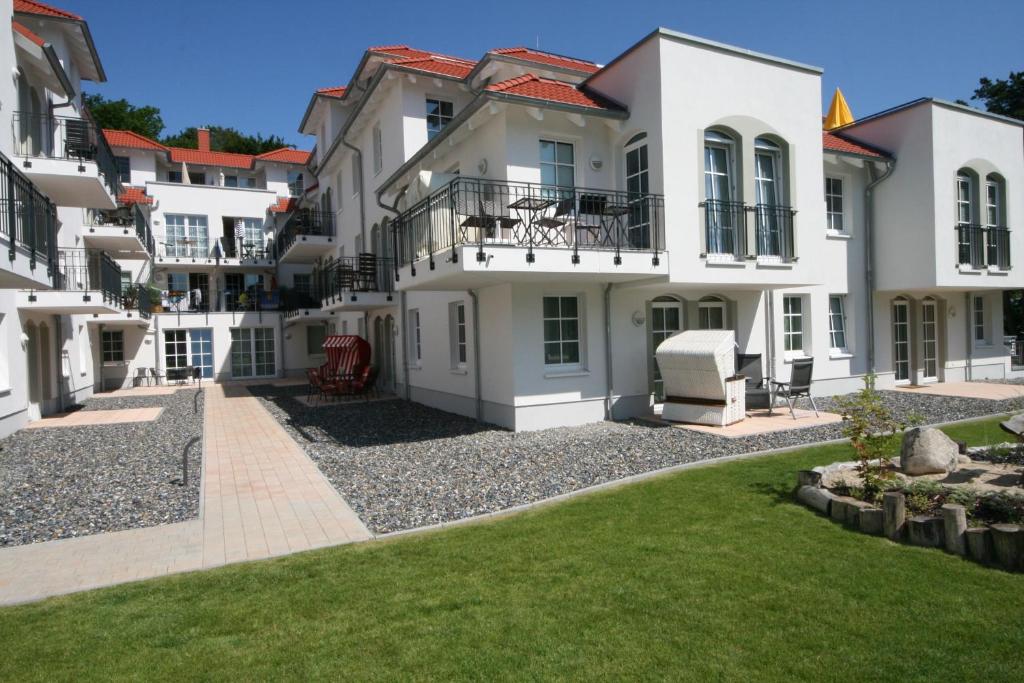 un grand bâtiment blanc avec une pelouse devant lui dans l'établissement Haus Meeresblick A 2 05 Baabedos mit Balkon, à Baabe