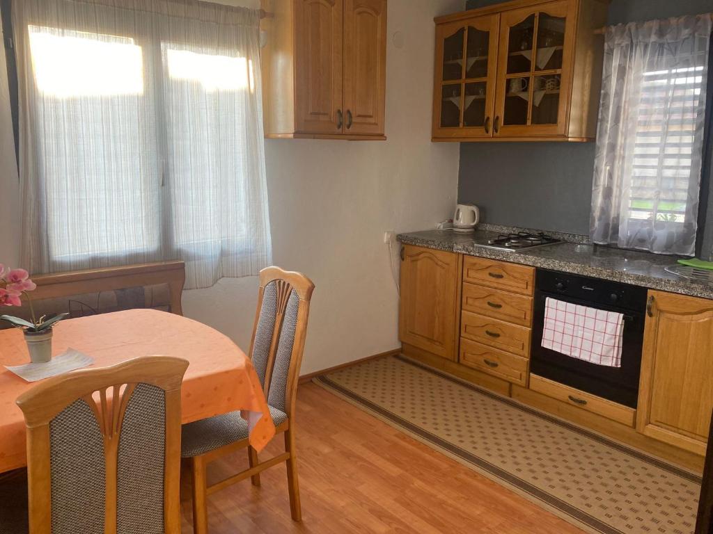 a kitchen with a table and a stove and cabinets at Villa Marijana in Varaždinske Toplice