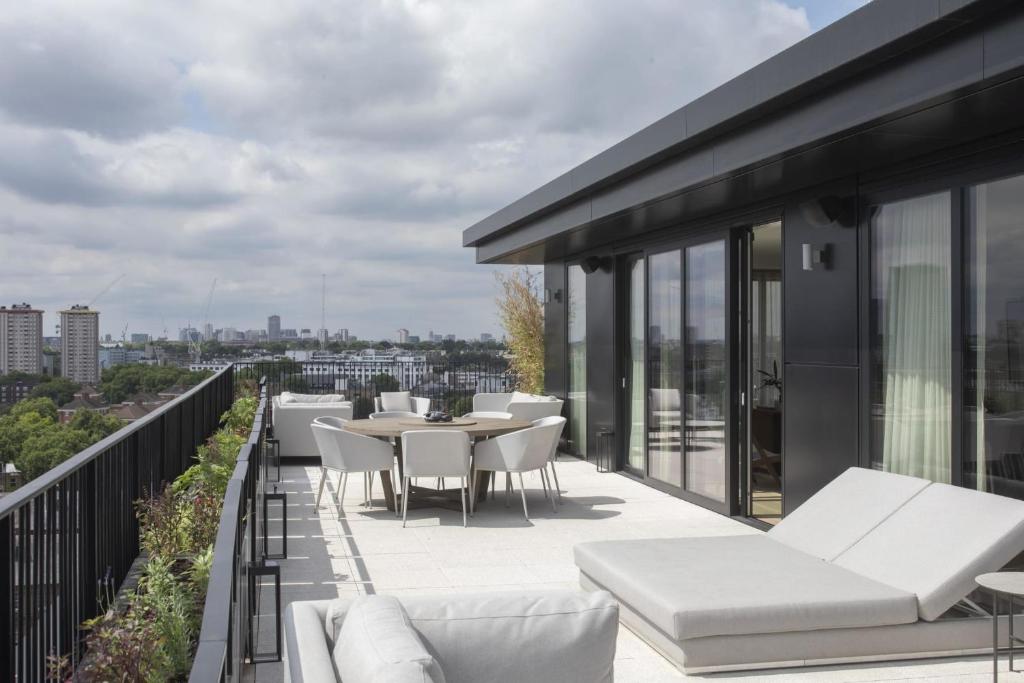a balcony with white furniture and a view of the city at Modern Apartments at Enclave located in Central London in London