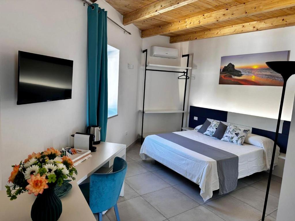 Schlafzimmer mit einem Bett und einem Schreibtisch mit einem TV in der Unterkunft Dimora Schiappone in Ischia