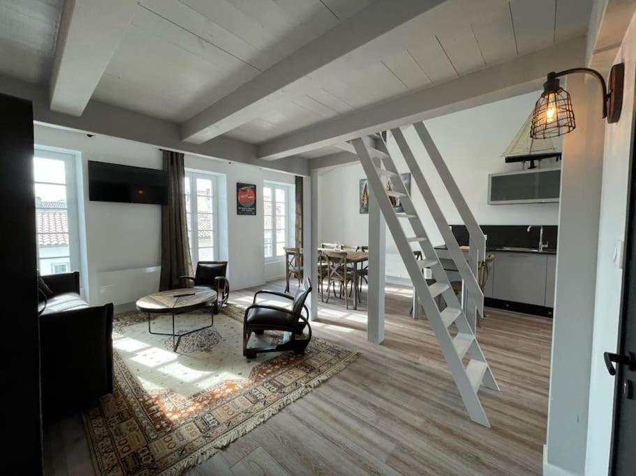 - un salon avec un escalier en colimaçon dans l'établissement Grand appartement ancien en centre ville, à La Rochelle