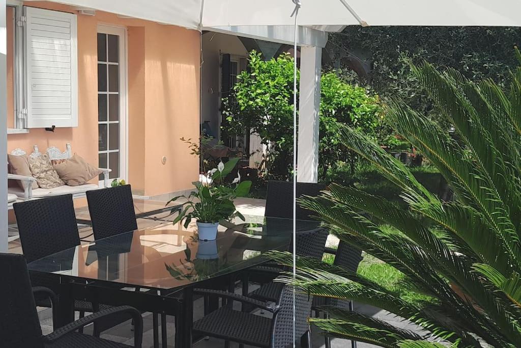 stół jadalny z krzesłami i parasolem w obiekcie Casa vacanze Gli Ulivi w mieście Sarzana