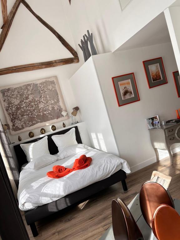 a bedroom with a bed with two red roses on it at Auberge de la rose in Anet