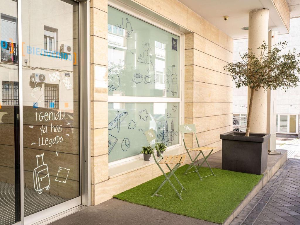 una tienda frente con dos sillas y un cartel en la ventana en Ibis Budget Madrid Centro Las Ventas en Madrid