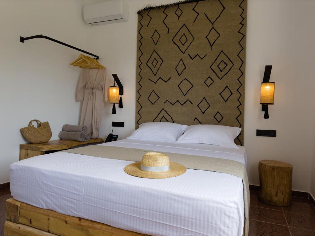 sypialnia z łóżkiem z kapeluszem w obiekcie Armeno Resort w mieście Marathias