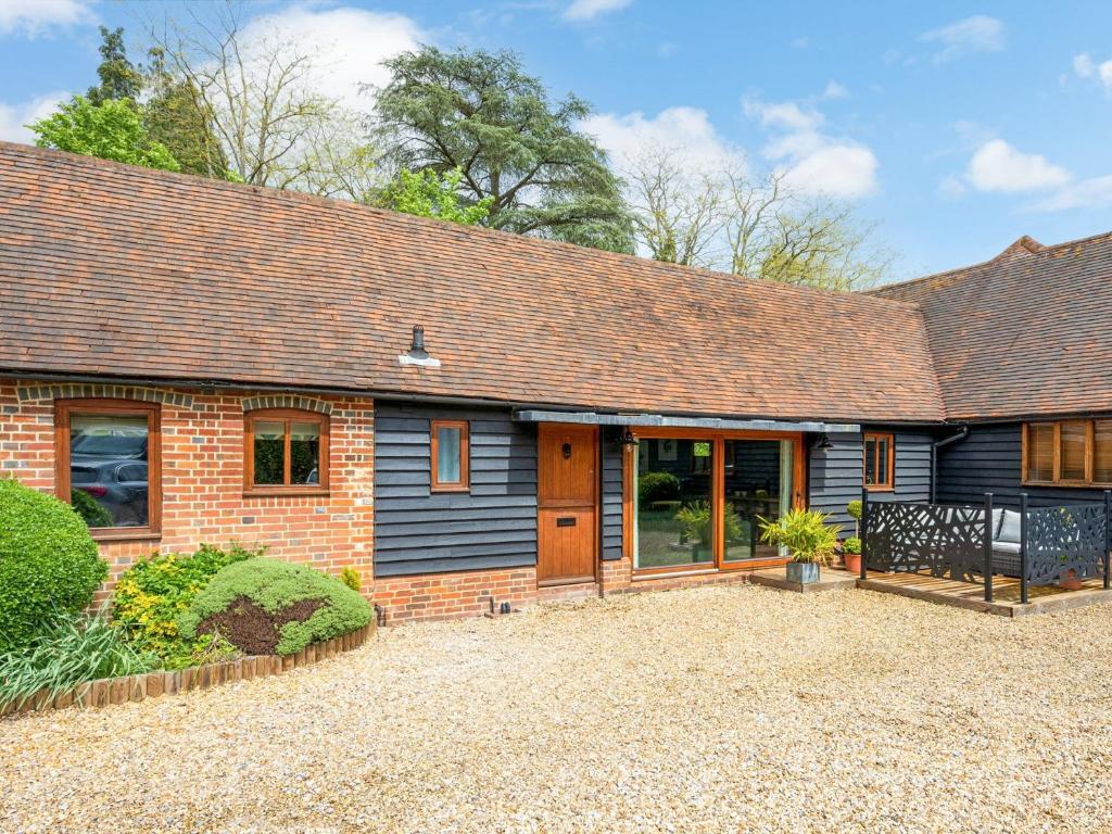 a home with a brick house with a roof at Lantern Lodge in Bramley