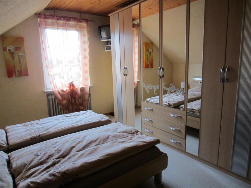 a bedroom with two beds and a dresser and a window at Ferienwohnung Freitag in Winsen