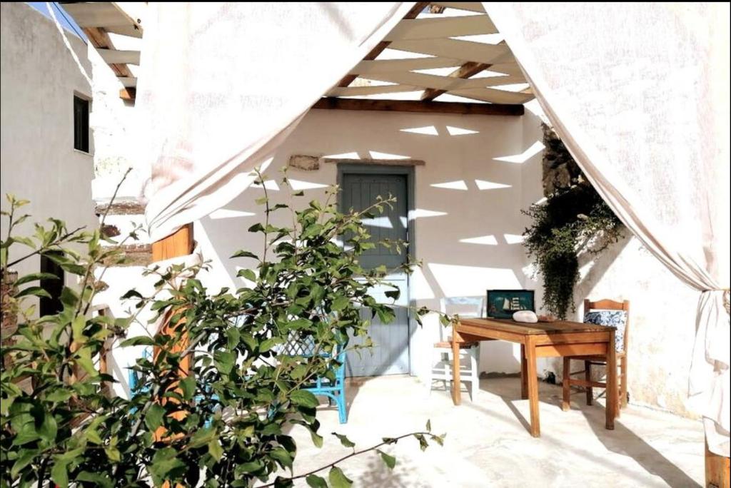 une maison avec une table en bois dans une cour dans l'établissement Naxos Mountain Retreat - Tiny House Build on Rock, à Kóronos