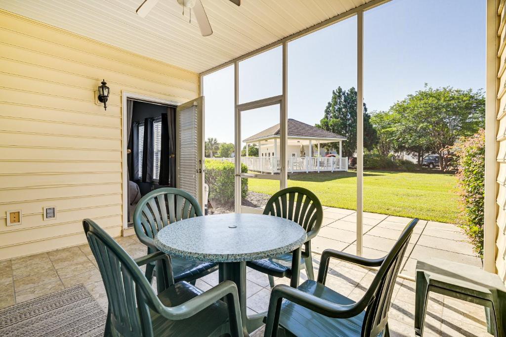 eine Terrasse mit einem Tisch und Stühlen auf einer Veranda in der Unterkunft Myrtle Beach Condo Golf Courses and Pool Access! in Myrtle Beach