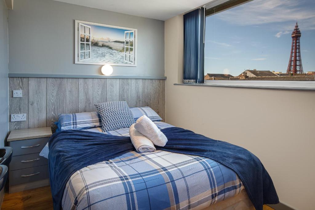 a bedroom with a bed and a window with a lighthouse at Seaside Suites Superior Family Apartments in Blackpool