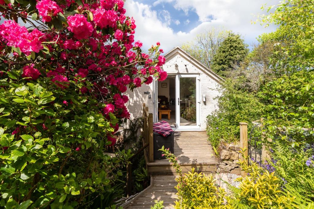 una casa de campo con flores rosas en la parte delantera en Merrivale Barn, en Constantine