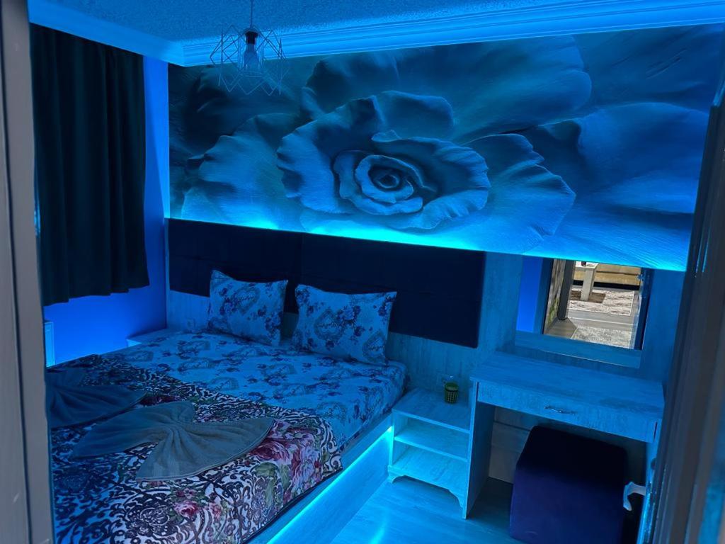 a bedroom with a bed in a room with blue lights at YAKAMOZ 27 SUİT APART in Bursa