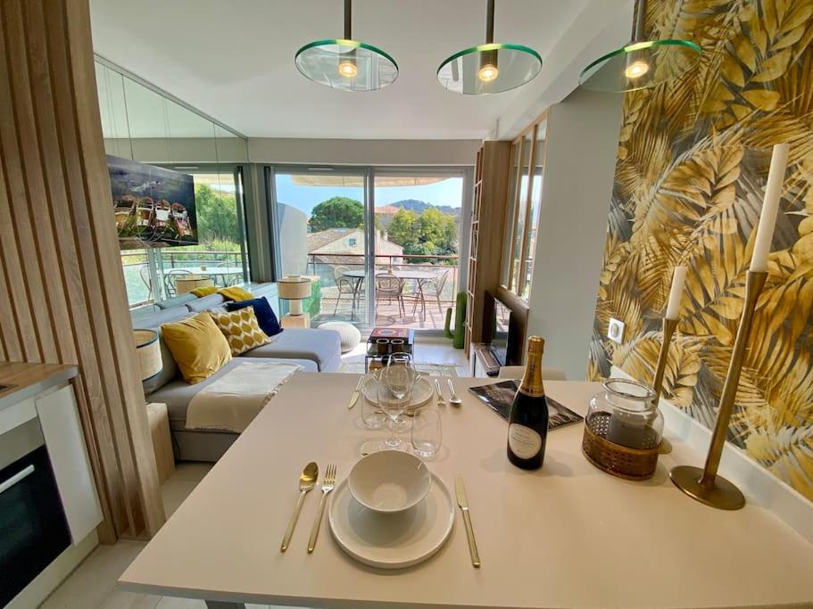 - un salon avec une table, des verres et une bouteille de vin dans l'établissement Appt Standing StTropez terrasse Piscine Parking, à Saint-Tropez