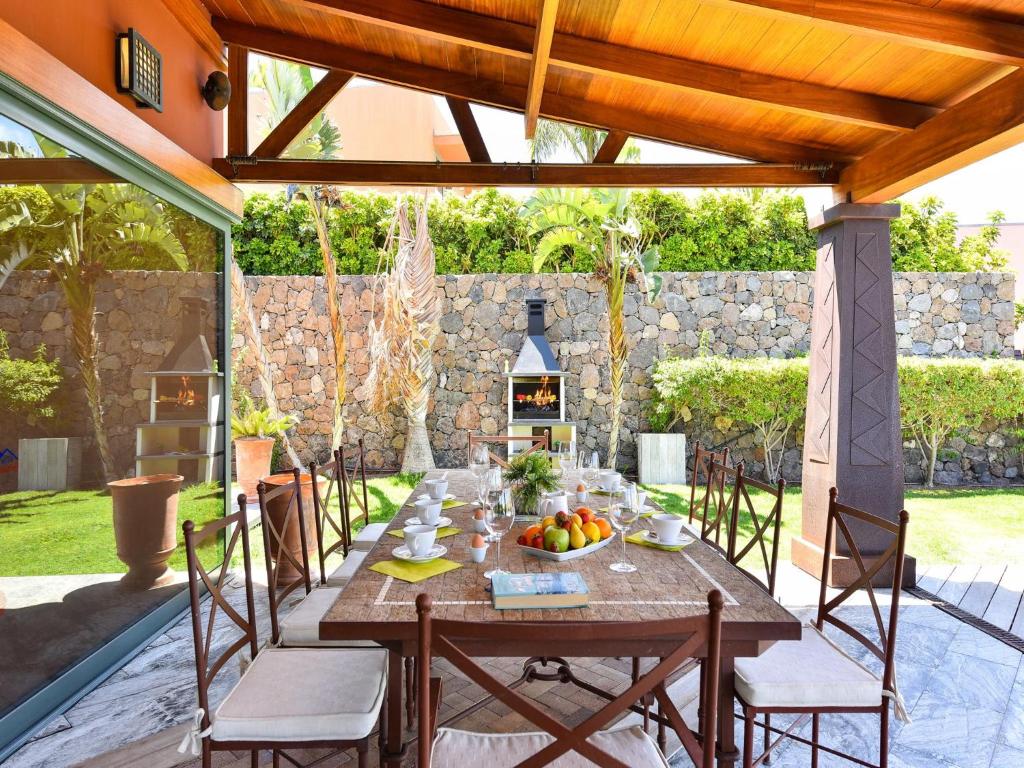 drewniany stół i krzesła na patio w obiekcie Villa Lavanda by VillaGranCanaria w mieście Maspalomas
