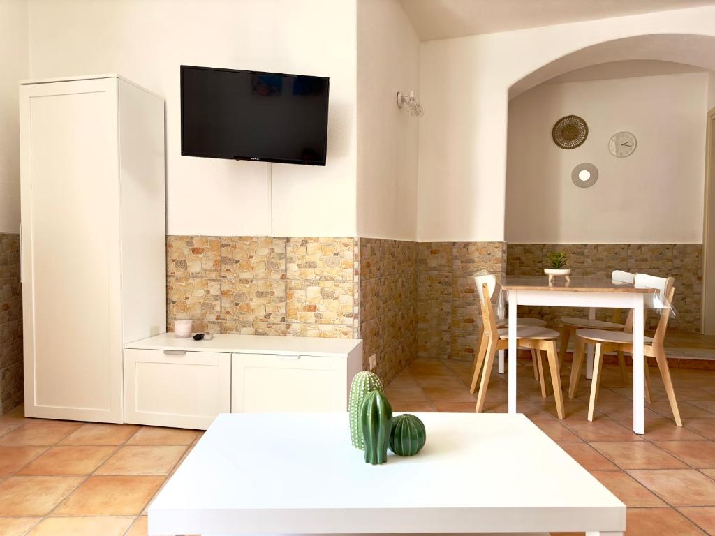 un soggiorno con tavolo e TV a parete di Dimora Saracena Forio a Ischia