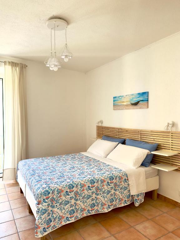 a bedroom with a bed with blue and white sheets at Dimora Saracena Forio in Forio d'Ischia