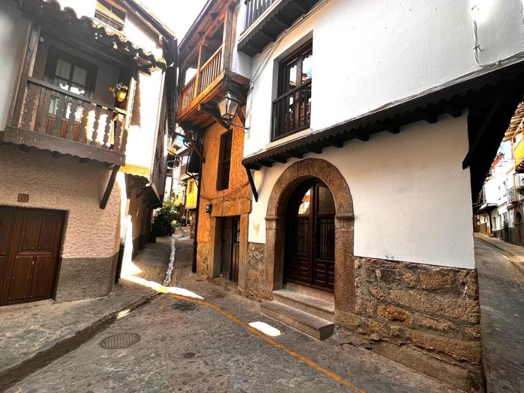 eine Gasse mit Gebäuden und einem Torbogen auf einer Straße in der Unterkunft CR "Calle Real" en la Sierra de Gredos in Villanueva de la Vera