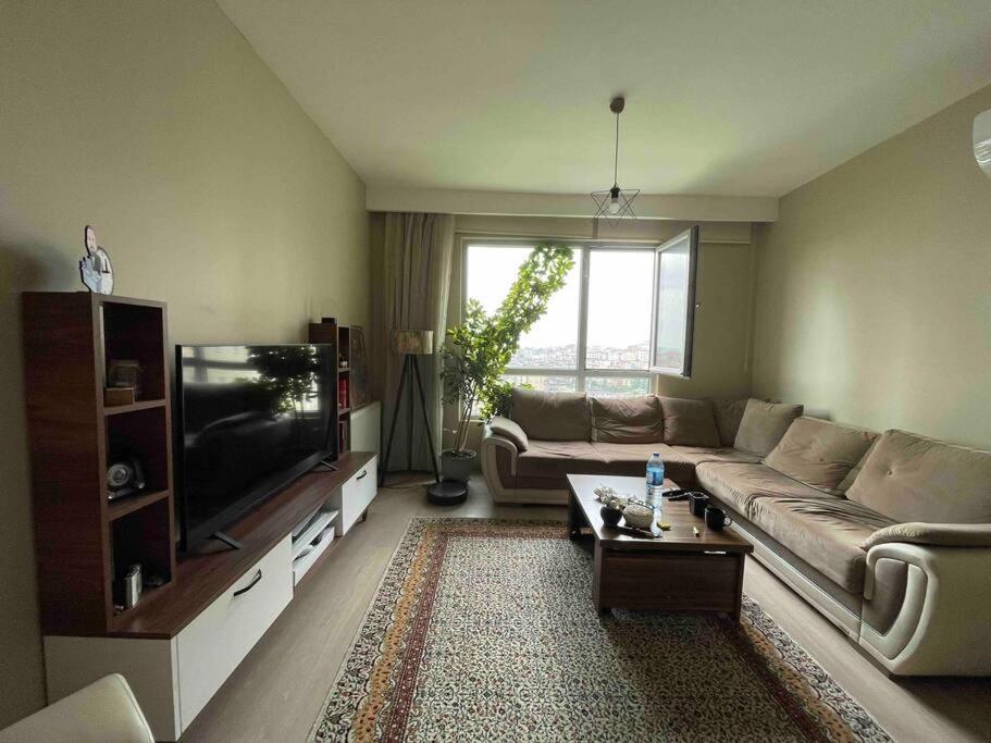 a living room with a couch and a tv at Açık havuz ve deniz manzarası sunan site ev in Istanbul