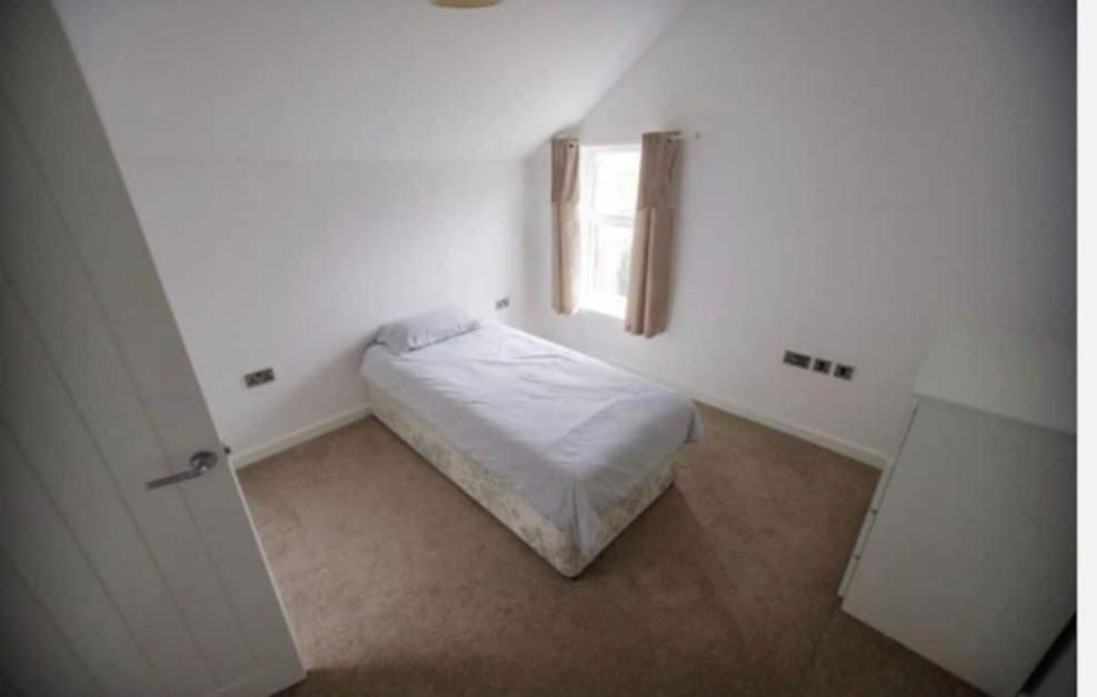een kleine slaapkamer met een bed en een raam bij Open plan house overlooking penshaw monument is in Sunderland