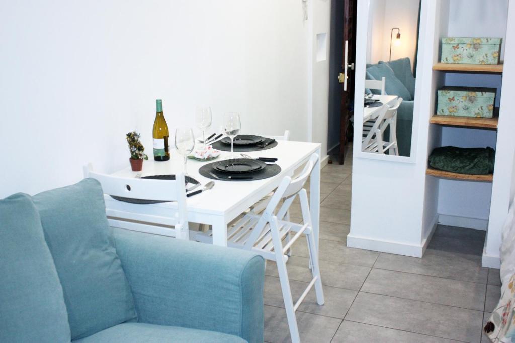 mesa de comedor blanca con sofá azul en Stylish Studio Gio 211, en Las Palmas de Gran Canaria