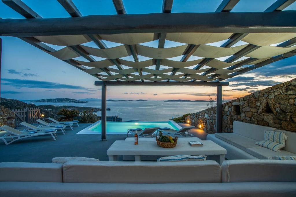 patio con divano e piscina di Villa Alitis by Mykonos Rocks a Mykonos Città