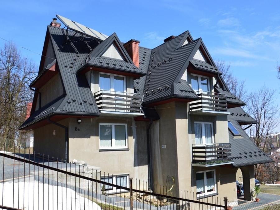 a house with a black roof on top of it at Pokoje Gościnne Pod Gubałówką in Zakopane