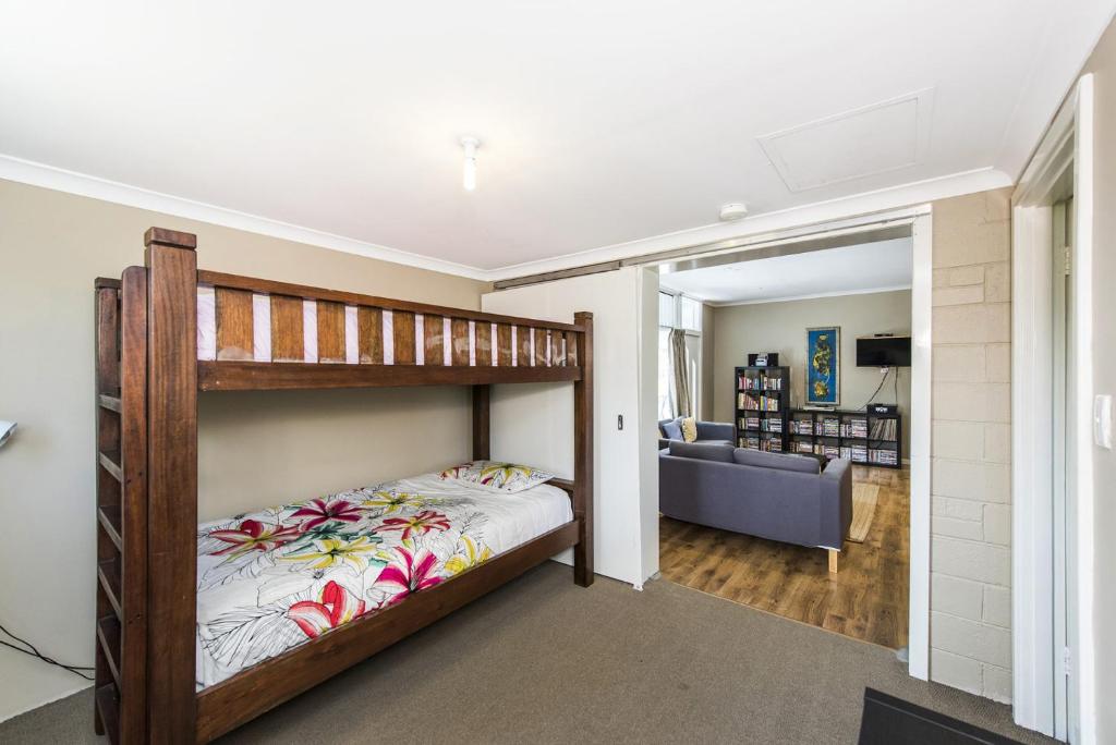 ein Schlafzimmer mit einem Etagenbett und ein Wohnzimmer in der Unterkunft Blueshack - Walking Distance To Foreshore in Guilderton