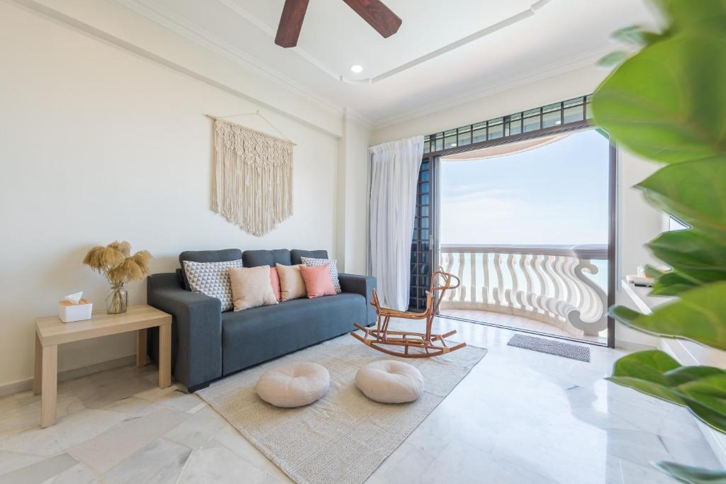 d'un salon avec un canapé bleu et d'un balcon. dans l'établissement PortDickson Cozy Muji Home 10Pax3BR 1min to beach, à Port Dickson