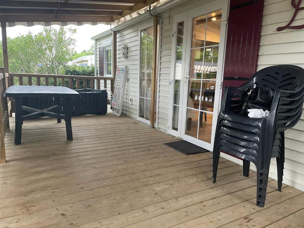 una veranda con panchina, tavolo e sedia di Mer et soleil a Les Sables Vignier